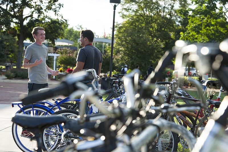 2 students talking near bicycles